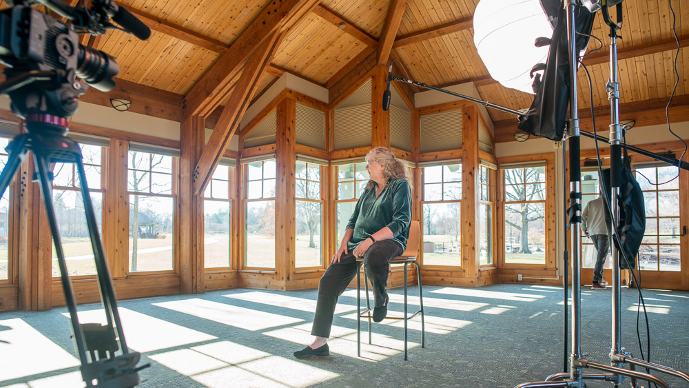 Behind the scenes view of interviews in a ruef video production. Cameras, tripods, lights, and microphones present.